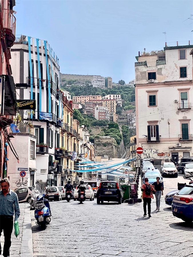 Quartier de Naples, au fond, colline et tout en haut un bâtiment fortifié dominant la ville