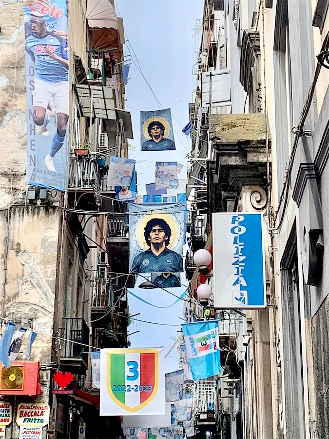 Rue décorée de plusieurs portraits de Maradona attachés aux balcons situés de part et d'autre de la rue ou apposés sur les façades, Naples, Italie